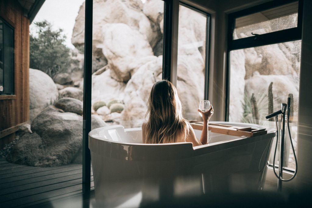 woman in a spa tub overlooking rock formations outside