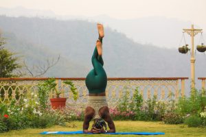 woman practicing different yoga styles outside with mountains in the background