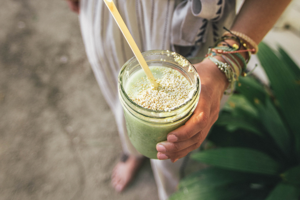 woman holding a green smoothie to help boost your immune system and fight infections