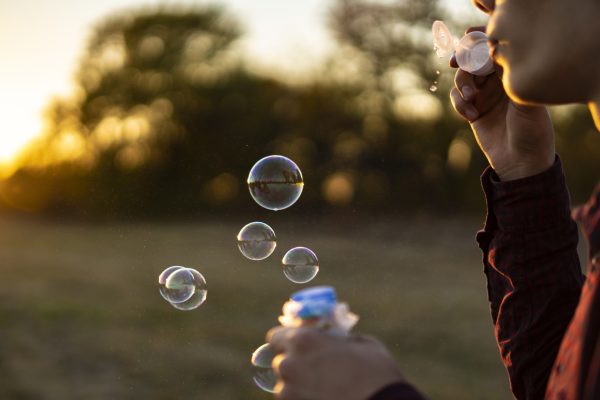 Person blowing bubbles in a field