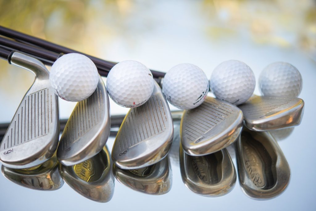 golf clubs and balls lined up in a row