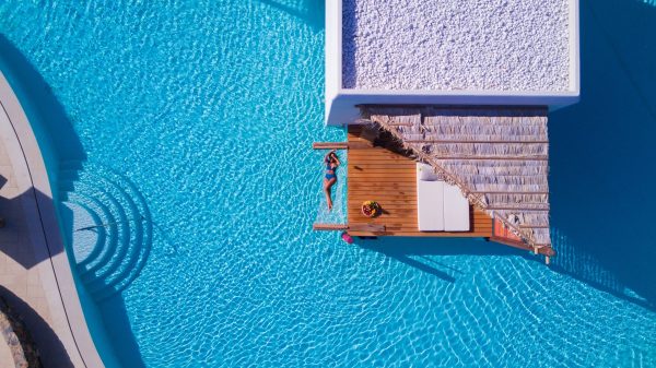 Stella Island Resort & Spa woman floating in pool aerial