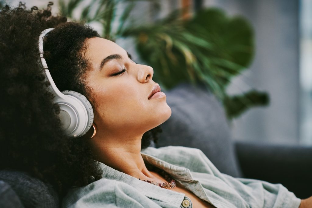 black woman with headphones listening to music for meditation