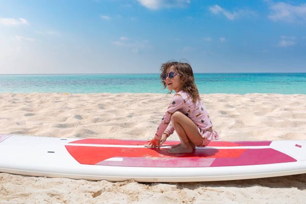 young girl on surfboard on beach